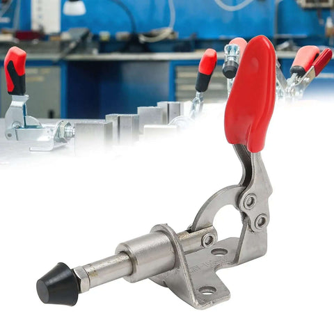 Stainless Steel Toggle Clamp With Quick Release, Heavy Duty Welding Fixture Hand Tool with red handle, in workshop setting.