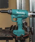 Badass 18V Lithium Ion Brushless Cordless Rivet Tool With Tough As Nails 20 KN Pulling Force For Quick One Stroke Installation Of Quarter Inch Aluminum And Steel Rivets Tool Only side view on workbench