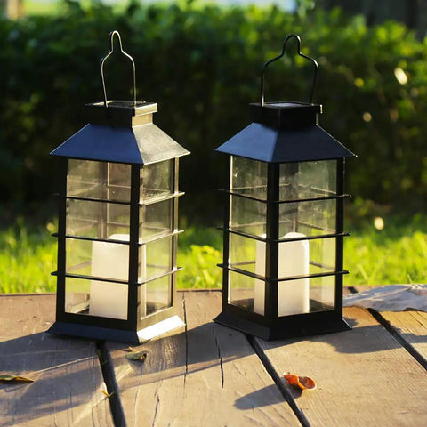 Two Pack Lit Solar Powered Outdoor Hanging Lanterns With Waterproof LED Flickering Flameless Candles, on wooden table