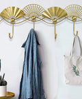Top Shelf Golden Wall Mounted Coat Rack Featuring Tough Fan Shaped Hooks Rust Resistant Steel with blue jacket and bag.