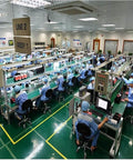 Electronics manufacturing line with workers assembling components in an industrial setting.