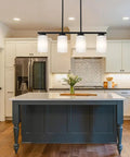Farmhouse Four Light Pendant Island Light in black finish with opal white glass shades above a kitchen island for modern rustic style