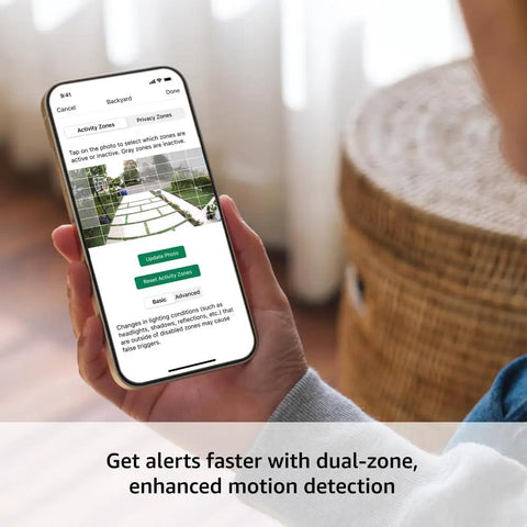 Person holding smartphone showing app interface for Outdoor 4 Wireless Security Camera System With Two Year Battery Life.