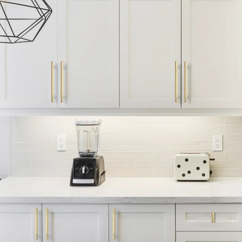 Modern kitchen with white cabinets featuring 10 Pack Brushed Brass Knurled Cabinet Handles 5 Inch Center to Center, gold-toned pulls installed.