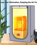 Resin 3D Printer Enclosure Tent With Ventilation System And LED Light Thermo Hygrometer Odor Busting Elimination 24 By 18 By 18 Inches Grey Protective Cover For Cleaner Safer Resin Printing showing interior view with yellow lighting