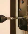 Pro Grabit 8430P Two Step Drill Bit And Screw Extractor Kit used to remove a screw from a door hinge. Close-up view.