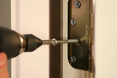 Pro Grabit 8430P Two Step Drill Bit And Screw Extractor Kit used to remove a screw from a door hinge. Close-up view.