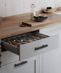Open kitchen drawer with 3 Inch Black Cabinet Hardware Set pull, showing silverware organizer; modern kitchen setup.