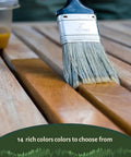 Top Shelf Penetrating Exterior Wood Stain In Acorn Brown 5 Gallon being applied with a brush on timber surface.
