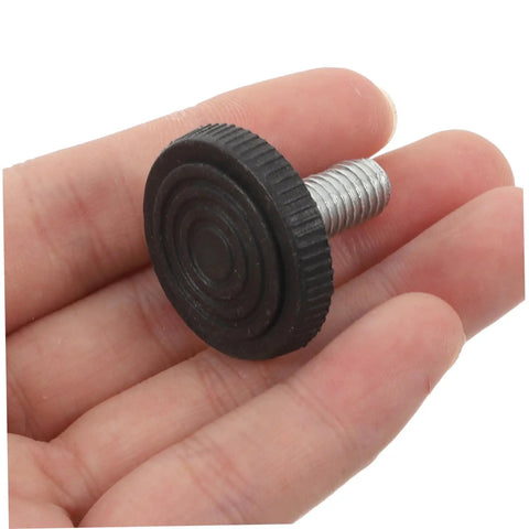 Close-up of a hand holding a small black plastic leveling shim with threaded metal screw. Not related to 20Pcs Furniture Leveling Shims Set.