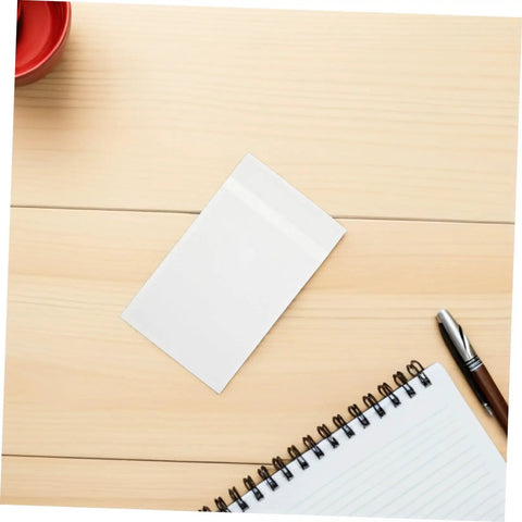 Translucent Glassine Envelopes 200 Pack 9x12 Plus 3cm Frosted Paper Bag on a wooden table with notebook and pen