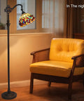 Stained Glass Tiffany Style Floor Lamp Standing 62 Inches Tall With Inlaid Crystal Accents beside yellow chair in living room