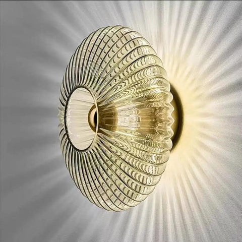 Awsinil Fluted Glass Wall Sconce, Modern Iron Round Decorative Wall Light with ribbed glass shade, emits soft light beams.