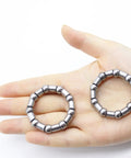 Hand holding two Four Pack Bicycle Crank Bearing Retainer Set With 8mm Ball Bearings Five Sixteenth Inch And Nine Balls Each Replacement.