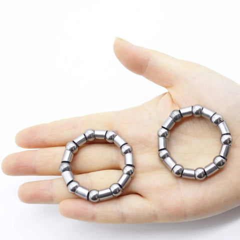 Hand holding two Four Pack Bicycle Crank Bearing Retainer Set With 8mm Ball Bearings Five Sixteenth Inch And Nine Balls Each Replacement.