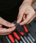 Hands holding a Six Pack Aluminum Folding Table Hinge For Cupboards And Dining Tables, emphasizing its compact, durable design.