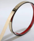 Peel and stick stainless steel molding strip with gold metalized mirror like finish, 16.4 ft long by 0.8 in wide, coiled view.