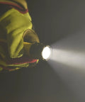Person holding PolyTac X 600 Lumen Tactical LED Flashlight With Ten-Tap Programmable Modes, beam illuminating darkness