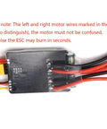 Close-up of Dual 30A Brushed ESCs for 2 to 6S RC vehicles bidirectional control with PWM input, showing wire connections.