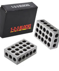 Two gray metal 1 x 2 x 3 inch parallel blocks with 23 holes each for milling setups.