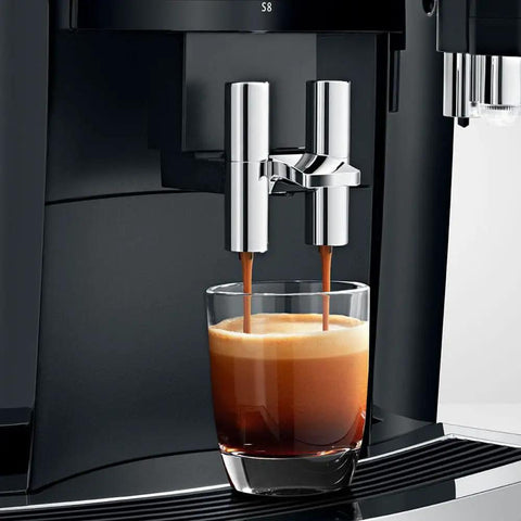 Recertified S8 Automatic Coffee And Espresso Maker In Slick Piano Black Featuring Color Touchscreen Aroma Grinder And Fine Foam Tech brewing espresso into a glass.
