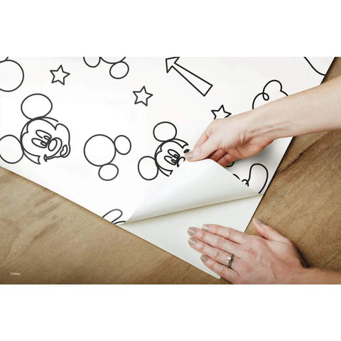 Hands applying Disney Mickey Mouse Icons Silver Peel And Stick Wallpaper Easy To Apply No Mess Removable And Repositionable Self Adhesive Wall Covering For Kids Rooms And Nurseries A Fresh Modern Metallic Silver Decor Upgrade