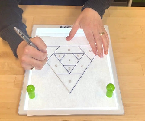 Person using Portable LED Light Pad For Crafting And Quilting 10 By 13 Inch, Ultra Bright Four Level Illumination For Clear Tracing And Cutting