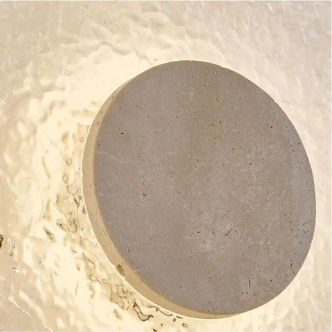 Close-up of yellow travertine round wall sconce modern indoor fixture with textured surface for vintage industrial style.