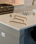 Six Pack Antique Brass Zinc Alloy Cabinet Pulls With 5 Inch Hole Center displayed on kitchen counter