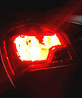 Rear view of car with Red 3156 3157 LED Turn Signal Bulbs For T25 Set Of 2 Hella Bright Back Up Reverse Brake Tail Lights illuminated