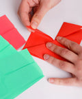 Person folding red Ultra Thin Tissue Paper Sheets 66x50cm 40 Pack with High Light Transmission for crafting.