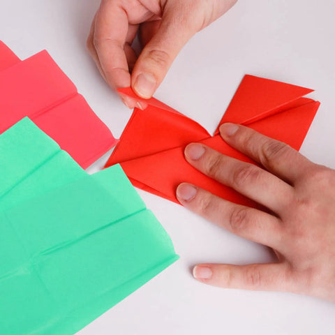 Person folding red Ultra Thin Tissue Paper Sheets 66x50cm 40 Pack with High Light Transmission for crafting.