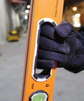 Close-up of hand holding 935L 24-Inch Magnetic Bubble Level with Adjustable Vial, V-Groove, and High Visibility Orange body