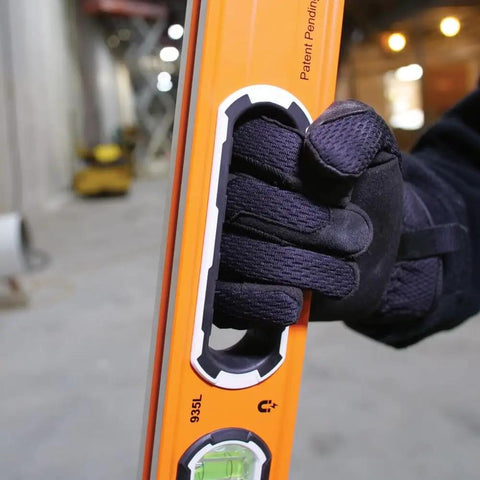 Close-up of hand holding 935L 24-Inch Magnetic Bubble Level with Adjustable Vial, V-Groove, and High Visibility Orange body