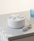 Ultra Compact Portable Mini Turbo Washer For Dorm Life And Travel Luggage with a white design and power cord on tabletop.