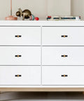 White chest adorned with 10 Pack Knurled Cabinet Knobs Matte Black And Champagne Bronze Set, shown installed on drawers.