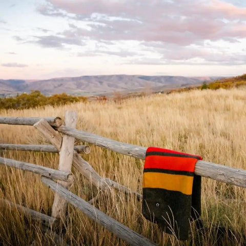 Heavyweight Wool Blanket For Cold Nights Camping Ready Outdoor Essential draped over wooden fence in a field