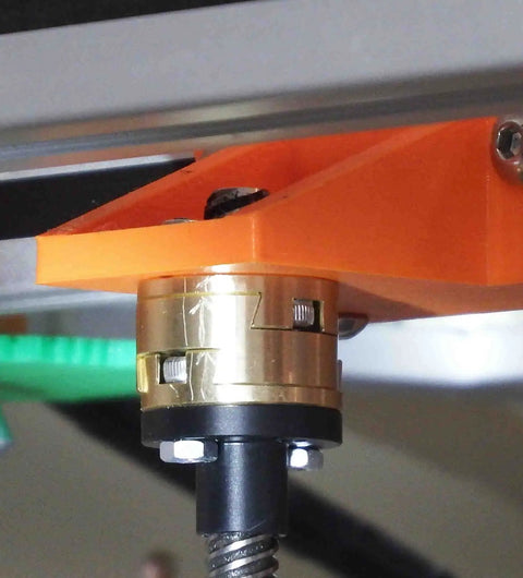 Close-up of a brass coupler for 3D printer Z-axis T8 lead screw installed, showing Boss Level Precision Coupling Set to minimize play and wobble.