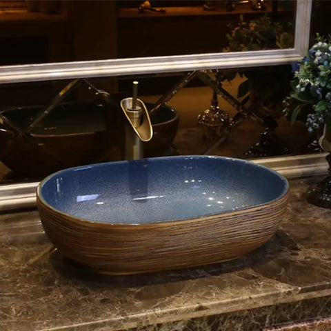 USZWBY Vessel Sinks Bathroom Vessel Sink Oval Ceramic Washbasin Vintage Art Countertop Basin with blue interior on marble surface