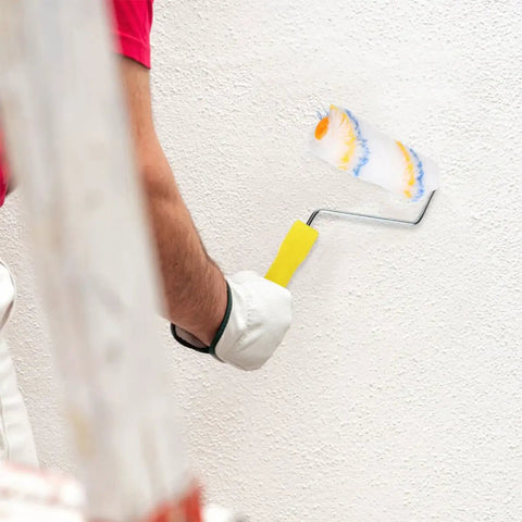 Person using a 20 Pack Mini Paint Roller Kit With High Density Foam Covers for spot touch ups on textured wall.