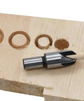 Kickass Eight Piece Wood Plug Cutter Drill Bit Set Offering Straight And Tapered Options For Heavy Duty DIY Projects And Home Renovations Real Deal Steel Bits That Slice Clean Every Single Time. Close-up of a steel plug cutter on wood.