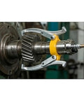 Hella Durable Hydraulic Gear Puller Set With Hand Pump 50 Ton extracting a gear from a shaft in a garage workspace.