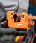 Go-To Mini Tubing Cutter For 1-1/8 Inch OD Aluminum And Copper Tubing With Spare Blade shown cutting copper pipe