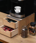 Double Tier Wooden Coffee Maker Stand With Pull Out Storage Drawer For K Cups And Capsules Countertop Brew Organizer Rack arrangement with coffee pods and brewer.