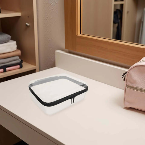 Built Different Clear Hard Shell Zipper Case For Travel Toiletries And Makeup Organizer on a dresser surface next to a pink bag.