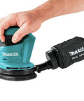 Person using Cordless 5 Inch Random Orbit Sander 18V LXT With Three Speed Settings 7000 9500 11000 OPM Large One Eighth Inch Orbit