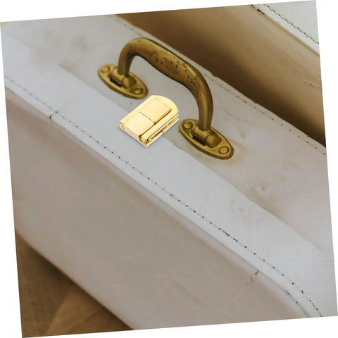 Close-up of Retro Iron Toggle Latch Kit on white wooden chest with golden handle, showing secure clasp installation.