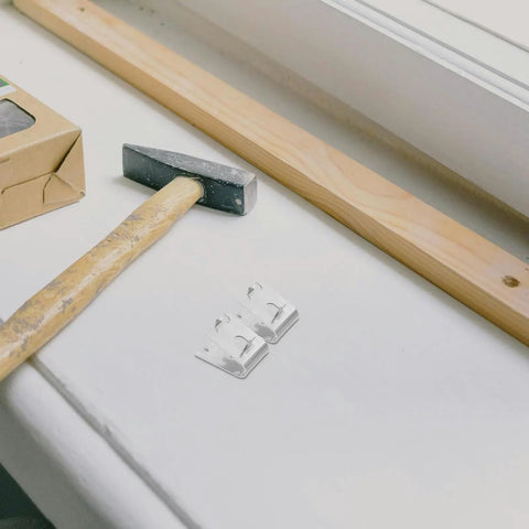 Heavy Duty Refrigerator Shelf Clips Set In Stainless Steel Brushed Finish next to hammer and wood block
