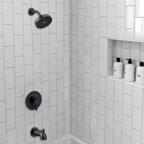 Matte black shower and tub trim kit for Moen Posi-Temp valve, installed in a white tiled shower with built-in shelf