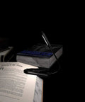 Grab And Go Clip On Book Light With 12 LED USB Rechargeable Battery illuminating an open book on a desk for night reading.